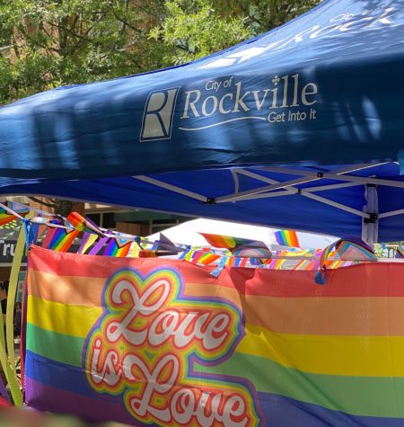 Traditional Pride Flag with the words 'Love is Love' hung from a City of Rockville tent